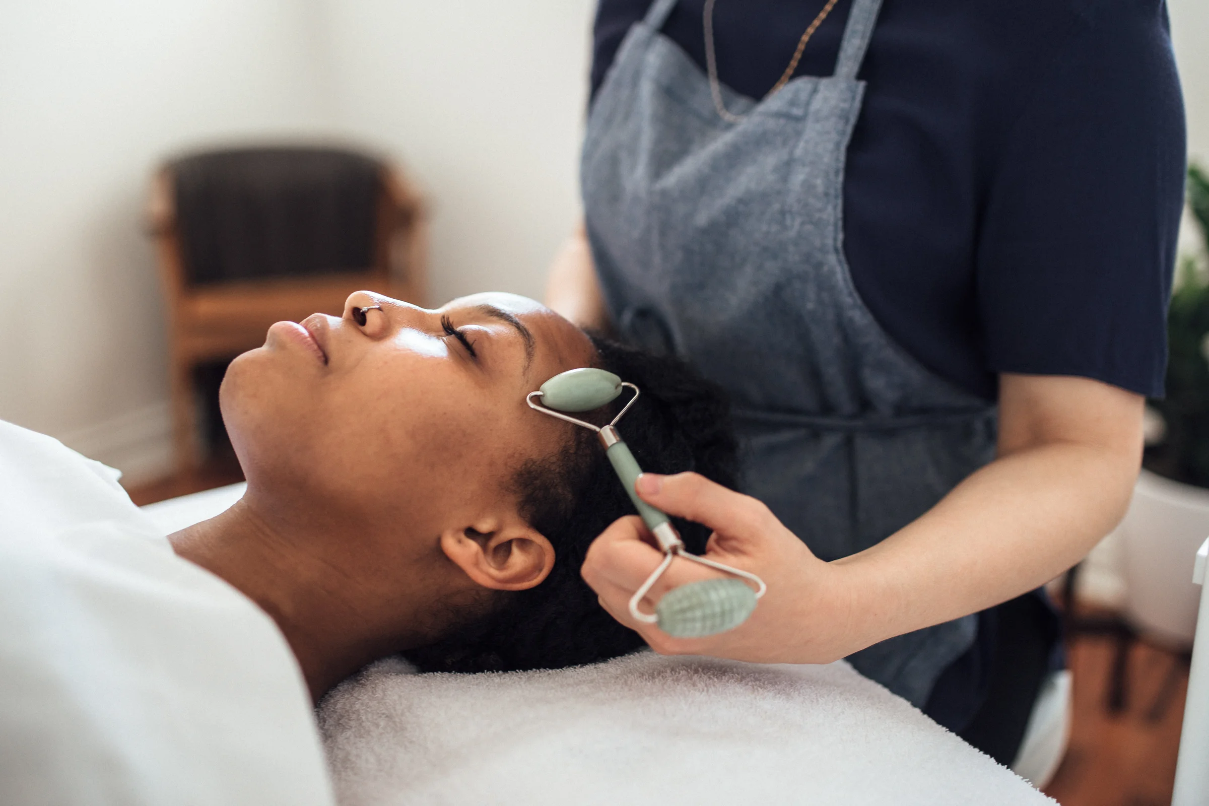 Photo of a facial massage with a roller tool.