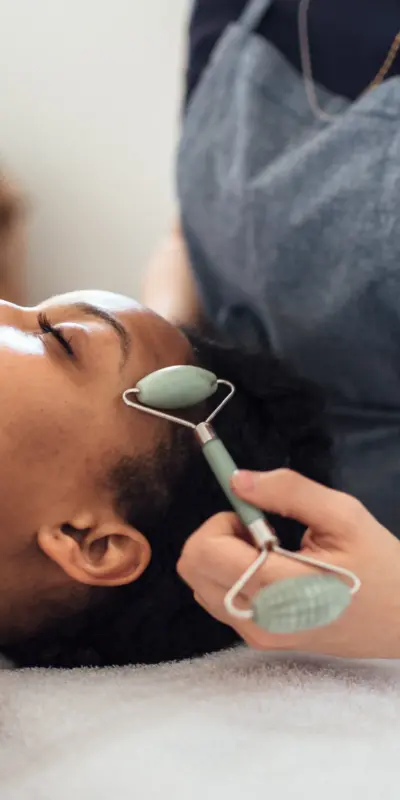 Photo of a facial massage with a roller tool.